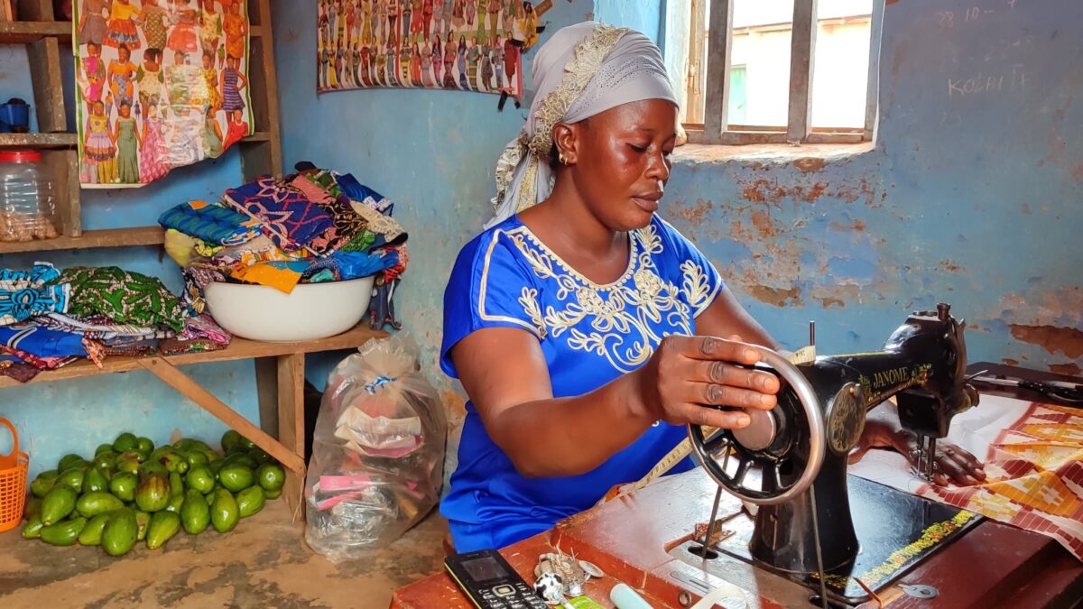 Ramatou assise sur sa machine à coudre